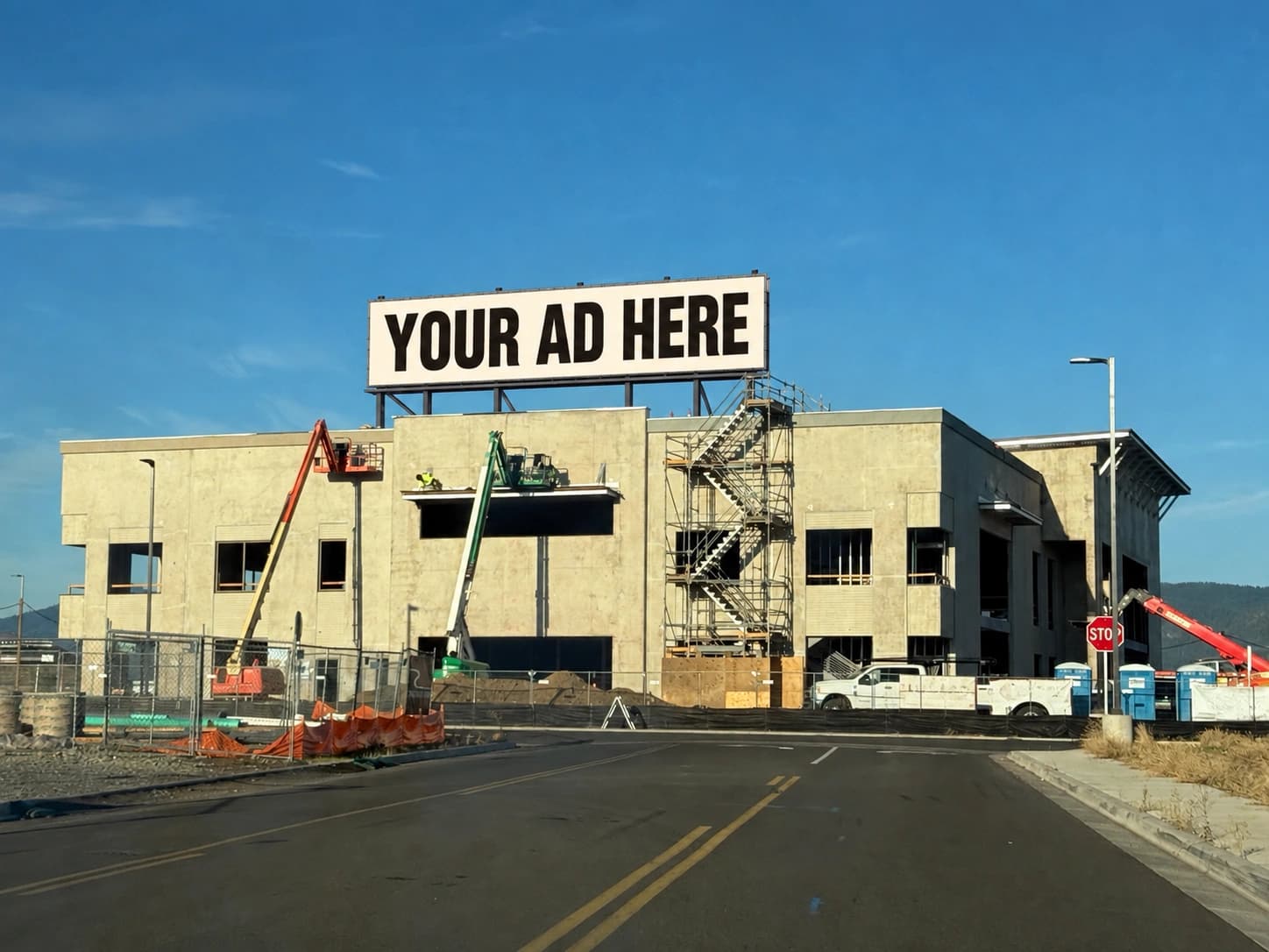 Reader photograph of a courthouse construction site with a fictional rooftop billboard reading Your Ad Here.